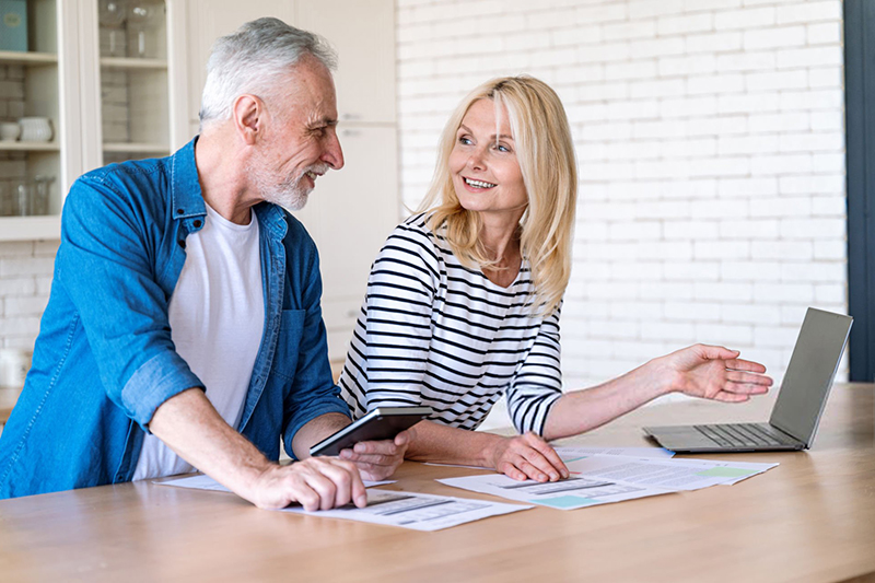 an elderly couple checking documents with a laptop, featured image for 'Unlocking Tax Benefits for Retirees in Spain'