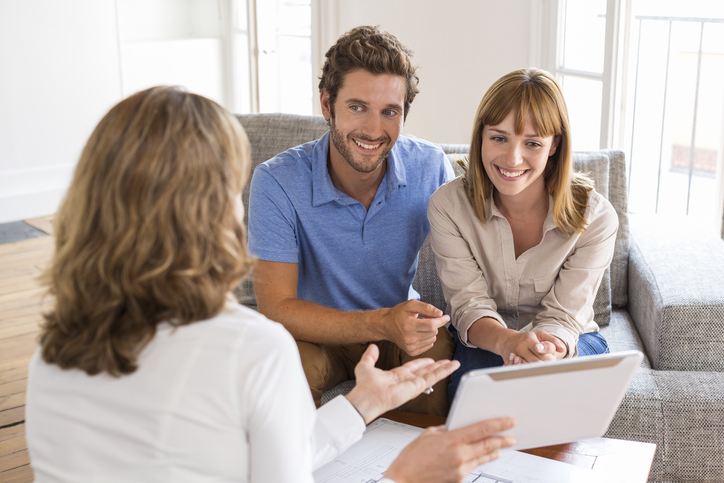 a group of people sitting around a table looking at a tablet, featured image for the article 